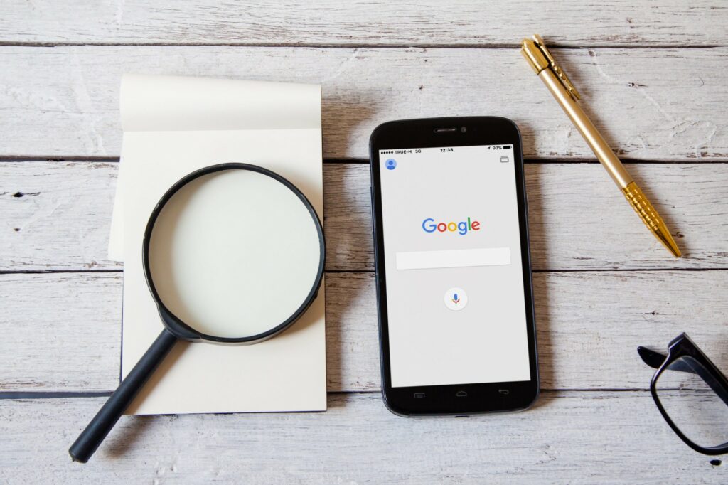 Recherche Google sur smartphone, loupe et carnet