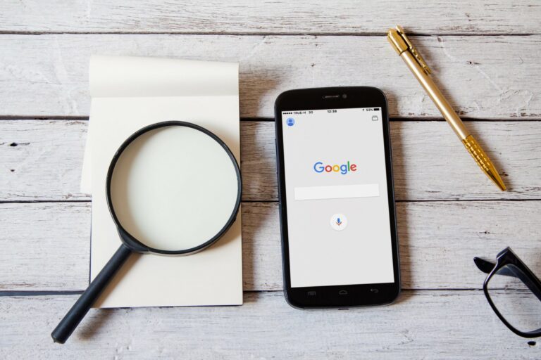Recherche Google sur smartphone, loupe et carnet